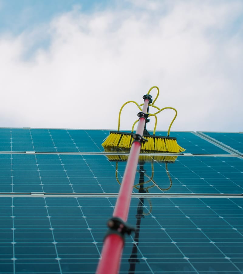 Hombre limpiando paneles solares Hombre limpiando paneles solares